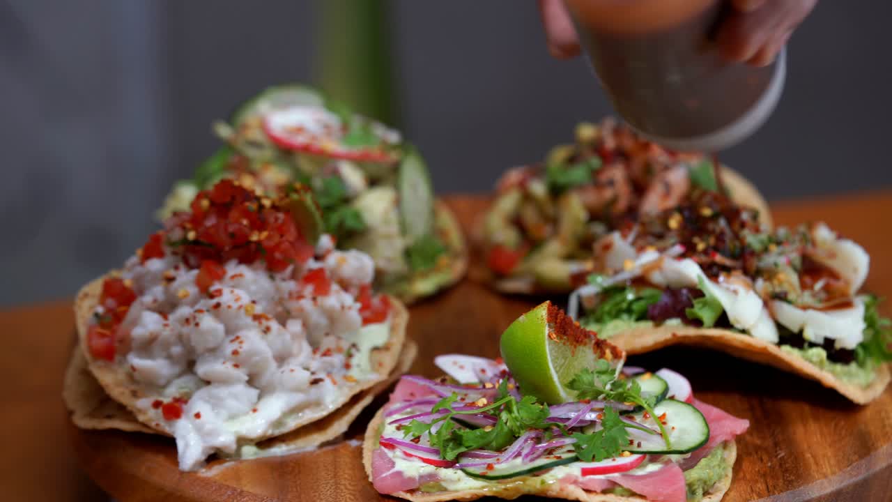 Tostadas de ceviche et poisson cru dressées sur une planche à La Musa